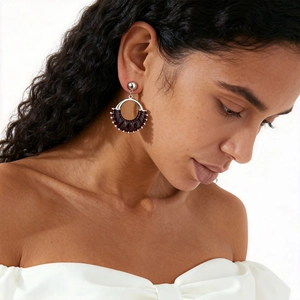 Close-up of geometric leather hoop earring with silver bead accents on model's ear