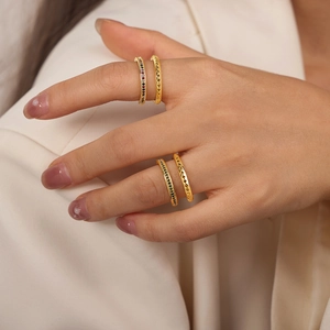 Set of four gold geometric rings featuring colored gemstones and V-shaped carvings