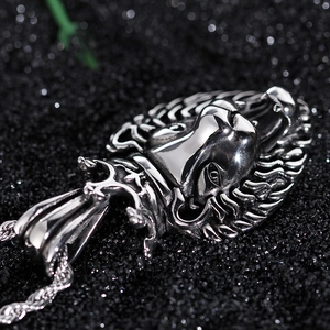 Macro shot of silver roaring lion head pendant with textured mane and twisted rope chain