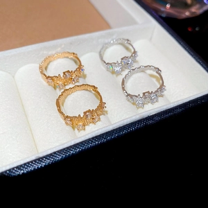 Macro detail of gold and silver irregular geometric hoop earrings with cubic zirconia stones