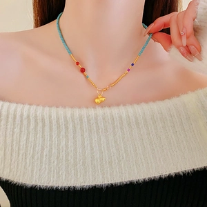 Detail of beaded gourd pendant necklace with colorful beads and gold-plated finish