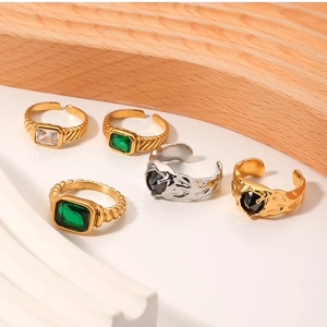 Gros plan sur les bagues en acier doré 18 carats avec zircons émeraude vintage