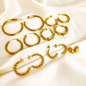 Golden stainless steel hoop earring set with twisted and smooth texture on silk
