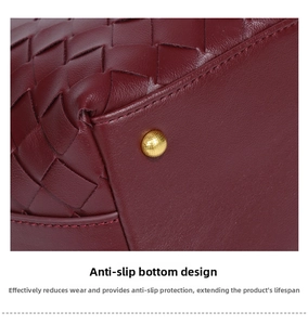 Macro shot of dark red woven leather bag bottom with protective gold metal stud