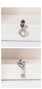 Detailed view of silver stud earrings with purple zircon heart and unicorn moon designs