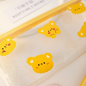 Detail of transparent PVC pencil case with cute yellow bear print and glitter finish