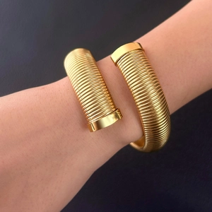 Polished gold-tone crossover coil cuff bracelet for women in minimalist modern style