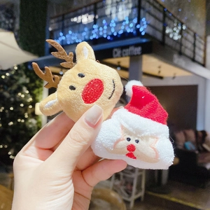 Close-up of plush reindeer and Santa Claus hair accessories with festive embroidery