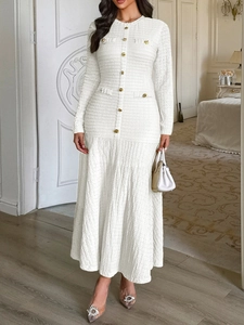Elegant white textured maxi dress with gold buttons and long sleeves on a model