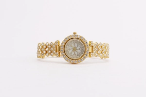 Macro view of gold flower watch dial with crystal bezel and mother-of-pearl finish