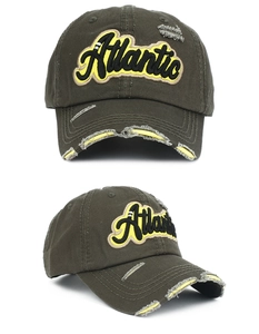 Détail de la casquette olive vintage avec broderie Atlantic jaune et détails de trous usés