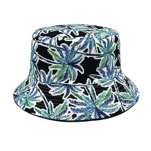 Dettaglio ravvicinato di stampe di palme tropicali e cuciture su un cappello a secchiello