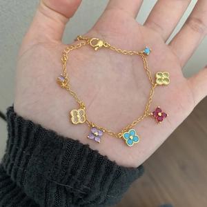 Bracelet doré avec cinq trèfles en zircon coloré et fermoir mousqueton ajustable