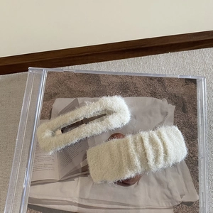 Detail of plush cream white hair clips set with oval and wavy rectangular faux fur designs