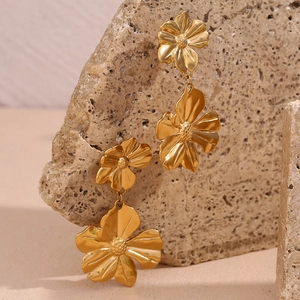 Detailed macro view of 18K gold plated stainless steel double flower dangle earrings