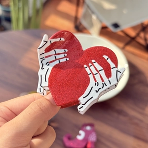 Halloween heart hair claw clip with red glitter finish and white skeleton hands design