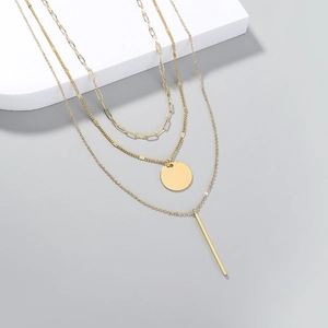 Three-layer gold necklace with paperclip chain, round disc, and vertical bar pendants