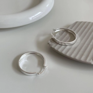 Detail of high-polished S925 sterling silver hoop earrings with classic latch closure