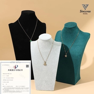 Velvet necklace bust displays showing gold clover star and moon pendants in three colors