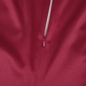 Détail de la fermeture éclair invisible sur une robe en satin bordeaux au grain fin