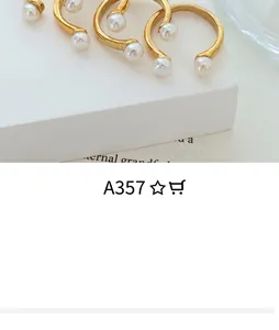 Close-up of matte gold metal cuff earrings with white pearls on geometric props