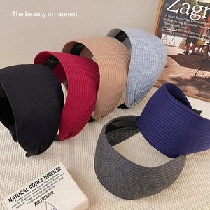 Macro detail of ribbed knit wide headbands in assorted colors like burgundy and navy