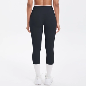 Détail du legging de yoga noir taille haute avec liseré blanc et effet galbant