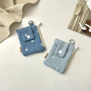 Detail of denim card holder with star pattern showing zipper and metal keychain ring