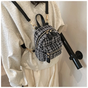 Detail of mini tweed backpack with black and white plaid pattern and leather straps