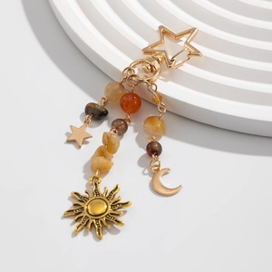 Detail of star and moon keychain with turquoise stones and golden metal fringe charms