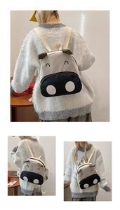 Detail showing the cute cow-themed canvas kids backpack with 3D ears and embroidery