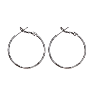Minimalist silver hoop earrings with faceted metal texture on a clean white background