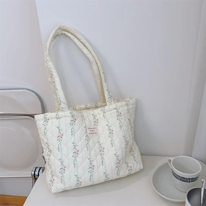 Gros plan du sac fourre-tout matelassé avec motif floral et étiquette en français