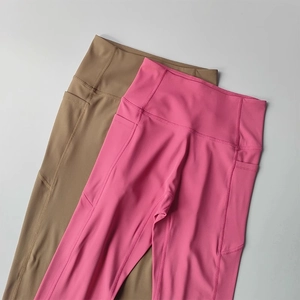 Detail view of high-waist yoga leggings with side pockets in pink and khaki colors