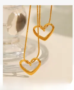 Détail de colliers chaîne serpent plaqués or 18K avec grands pendentifs en forme de cœur