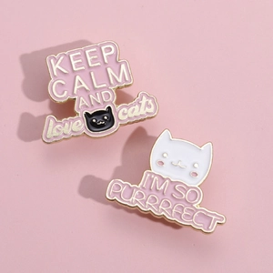 Detail of pink enamel cat badges with Keep Calm and I am So Purrrfect lettering