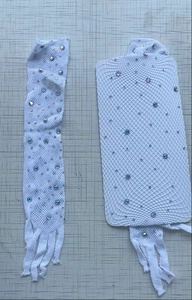 Detail of white fishnet gloves with sparkling rhinestones on textured gray background
