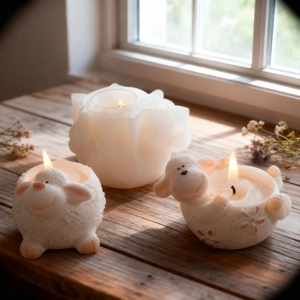 Three ivory sheep and rose candles on rustic wooden windowsill with warm lighting