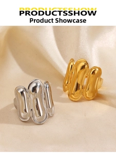 Detailed view of gold and silver organic wave rings on smooth beige satin fabric