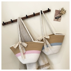 Détail de sacs fourre-tout tissés avec rayures contrastées et nœuds décoratifs en dentelle
