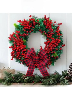 Detail of Christmas wreath with red berries, pine needles, and buffalo plaid bow on white wall