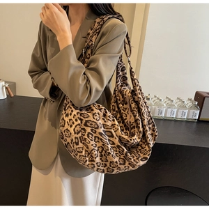 Detail of a large leopard print PU leather hobo bag worn with a stylish blazer