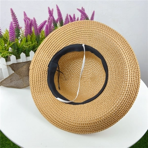 Detail of breathable straw sun hat featuring black sweatband and elastic chin strap