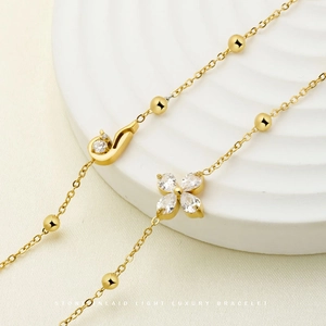 Gold plated stainless steel four-leaf flower bracelet with zircons on white platform