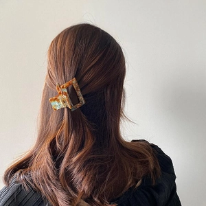 Classic amber pattern acetate hair claw clip for medium half-up hair styling on model
