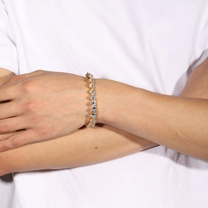 Close-up of a gold heart-shaped zircon tennis chain bracelet worn on a model wrist