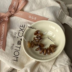 Detailed top view of retro amber hoop earrings with resin beads in a ceramic tray