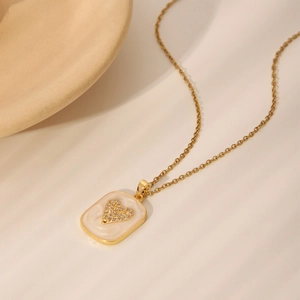 Golden necklace with a rectangular pendant featuring white enamel and a diamond heart