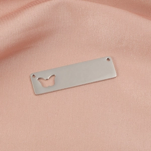 Close-up of a rectangular silver stainless steel pendant with butterfly cutout on pink silk