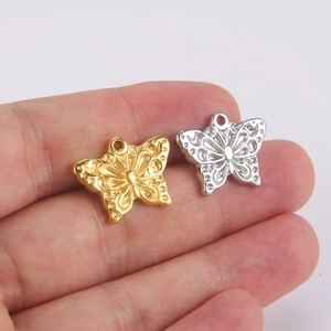 Hollow butterfly pendants in 18K gold and silver plating shown on hand for scale